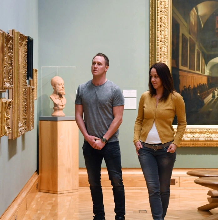 Un hombre y una mujer mirando arte en una galería