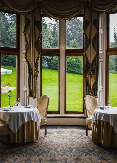 Mesas en el restaurante con vistas a un jardín verde