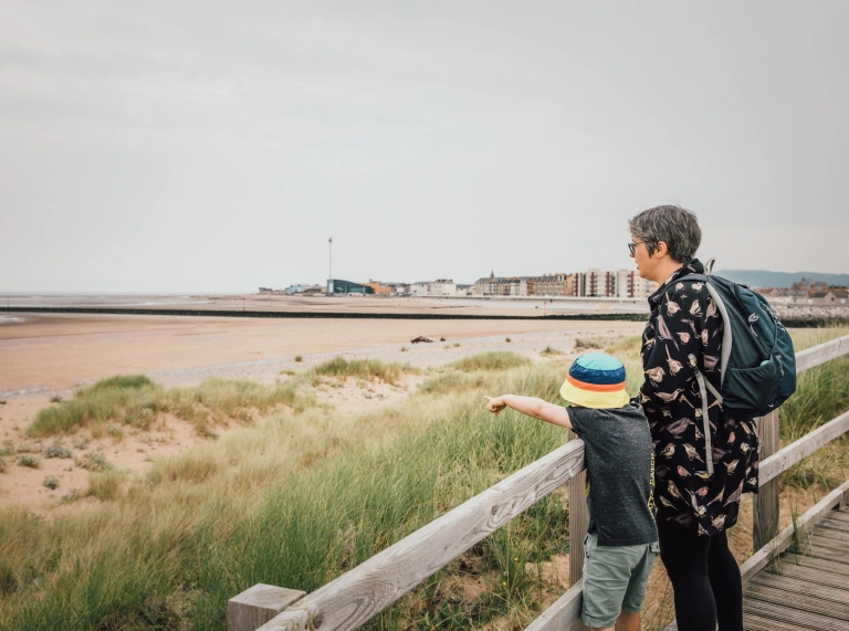 A woman and child looking out over the sand dunes.