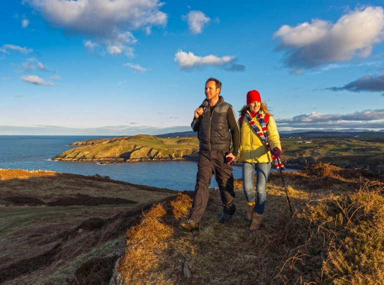 A couple walking on top of the cliffs.