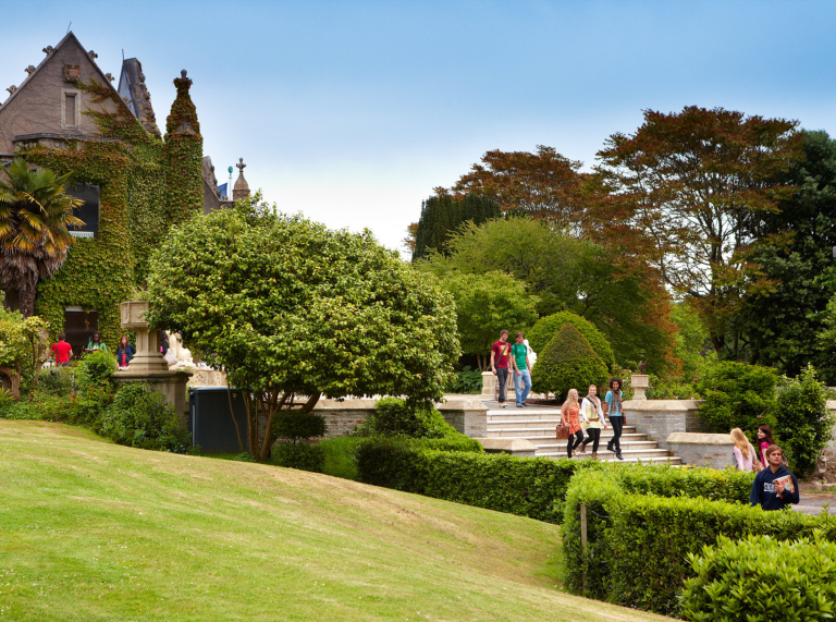 Students walking down steps, building with greenery