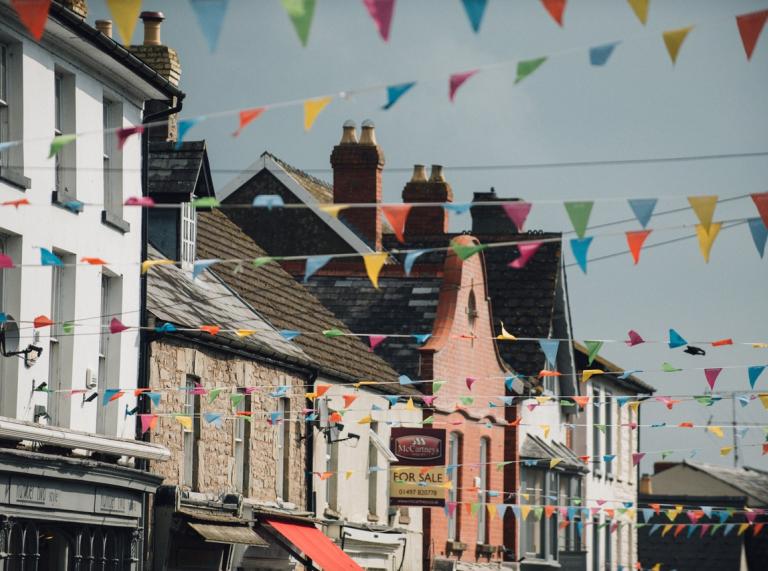 Bunting flags flying in the wind against the backdrop of historic Victorian houses