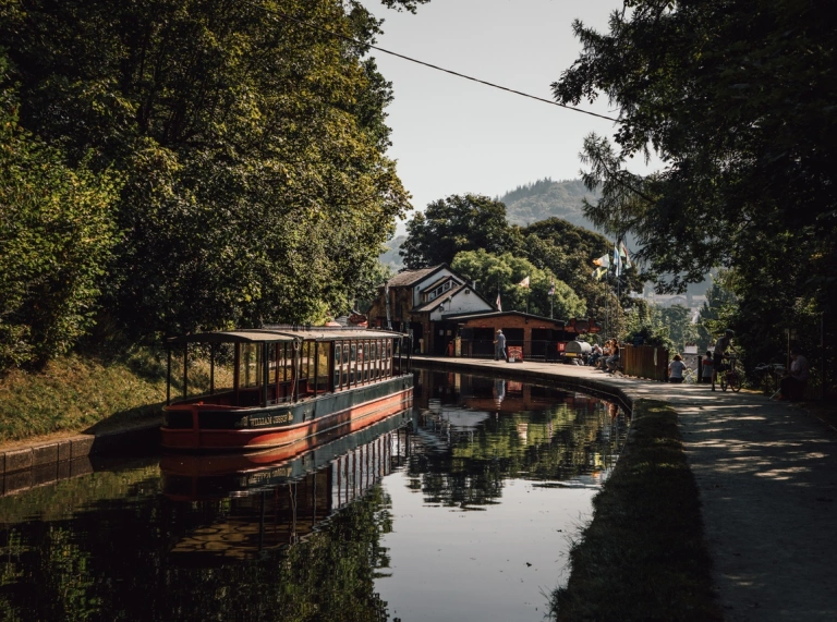 Image d'un bateau de canal sur fond de montagnes.