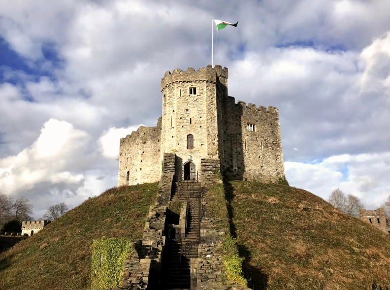 Norman Keep auf einem grünen Grashügel mit der walisischen Flagge auf der Spitze