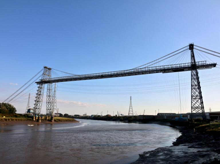 Un gran puente transportador industrial que cruza un ancho río