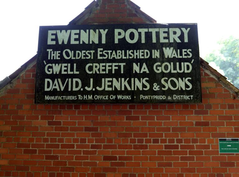 Un cartel de Ewenny Pottery en un edificio de ladrillos.