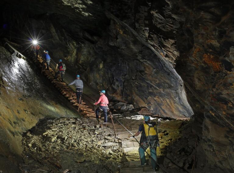 gente caminando por escaleras en la mina.