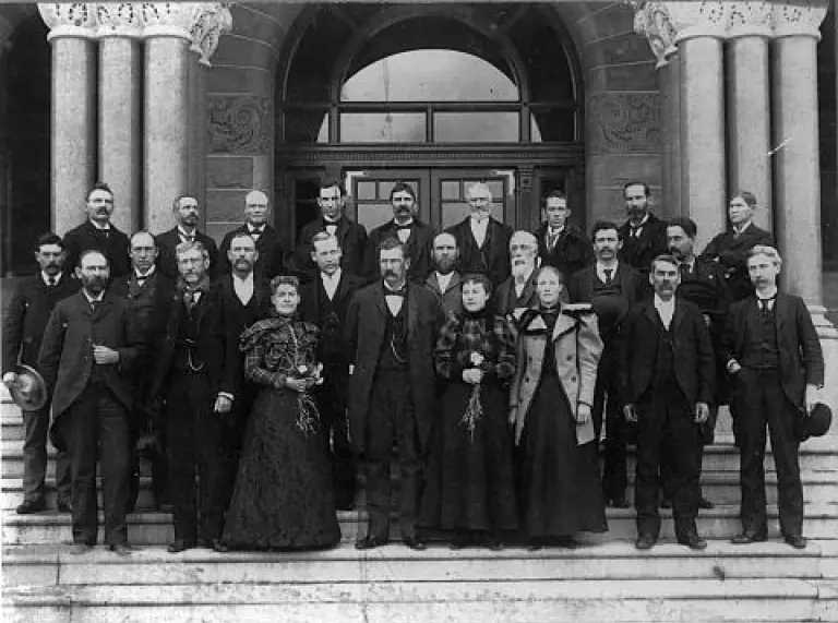 Fotografía en blanco y negro de los miembros del Senado de Utah - un grupo de hombres y mujeres parados en las escalinatas de un edificio antiguo