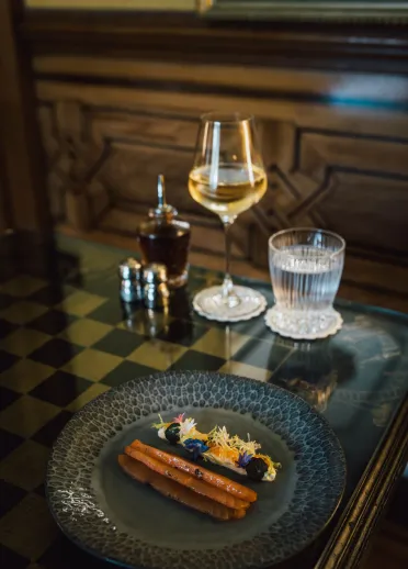 Un plato de comida con una copa de vino y un vaso de agua