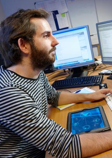 Hombre empleado en una computadora CEMAS - centro de excelencia en aplicaciones móviles y servicios, Universidad de Gales del sur