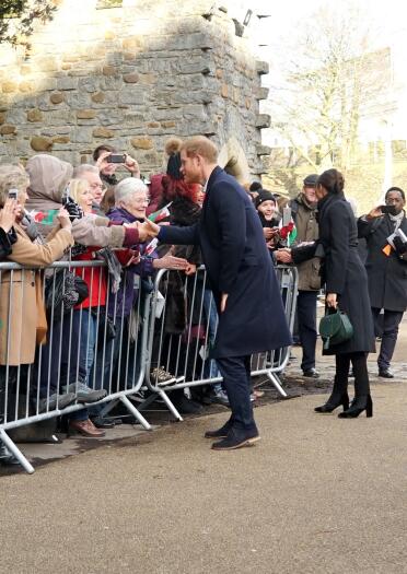 Le duc et la duchesse de Sussex, le prince Harry et Meghan Markle salue la foule derrière des barrières au château de Cardiff.