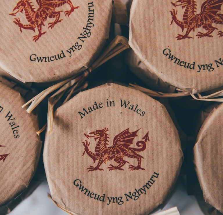 A row of glass jars with 'Made in Wales' and a red dragon stamped on top.