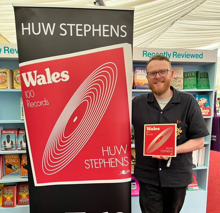 A man standing next to a banner.