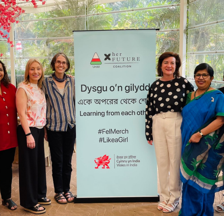 Women in front of Urdd poster