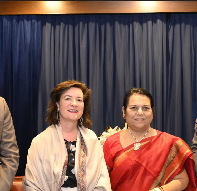 Two women in between two men smiling for camera