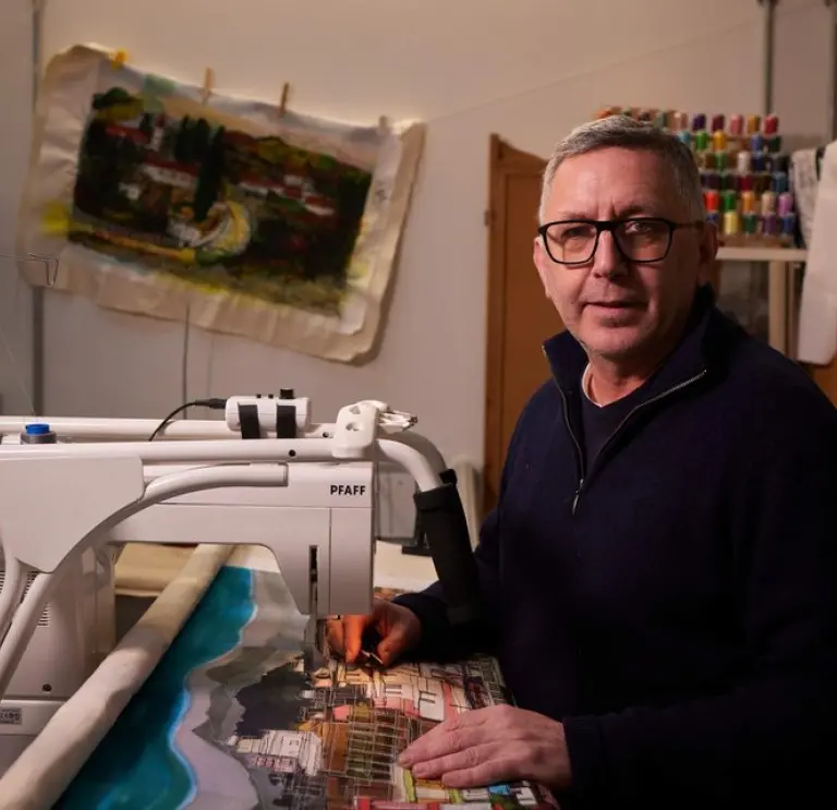 Man sat at table making art