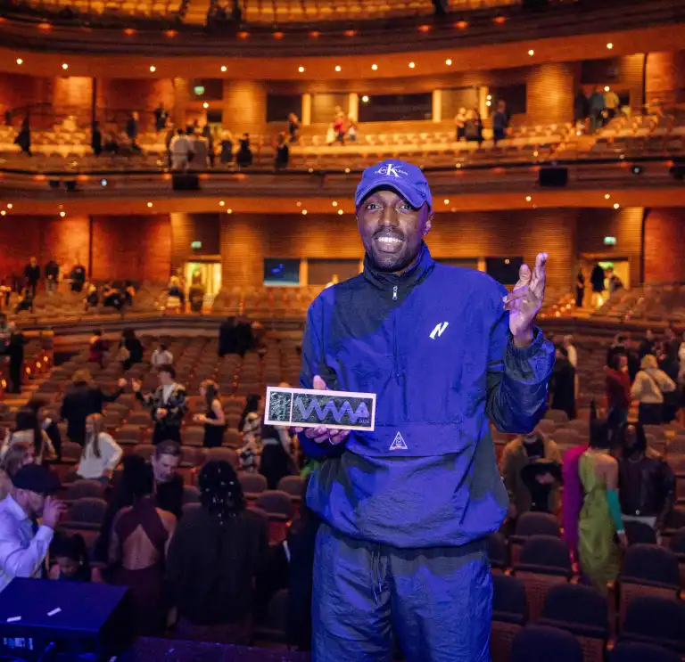 A man standing on stage holding an award.