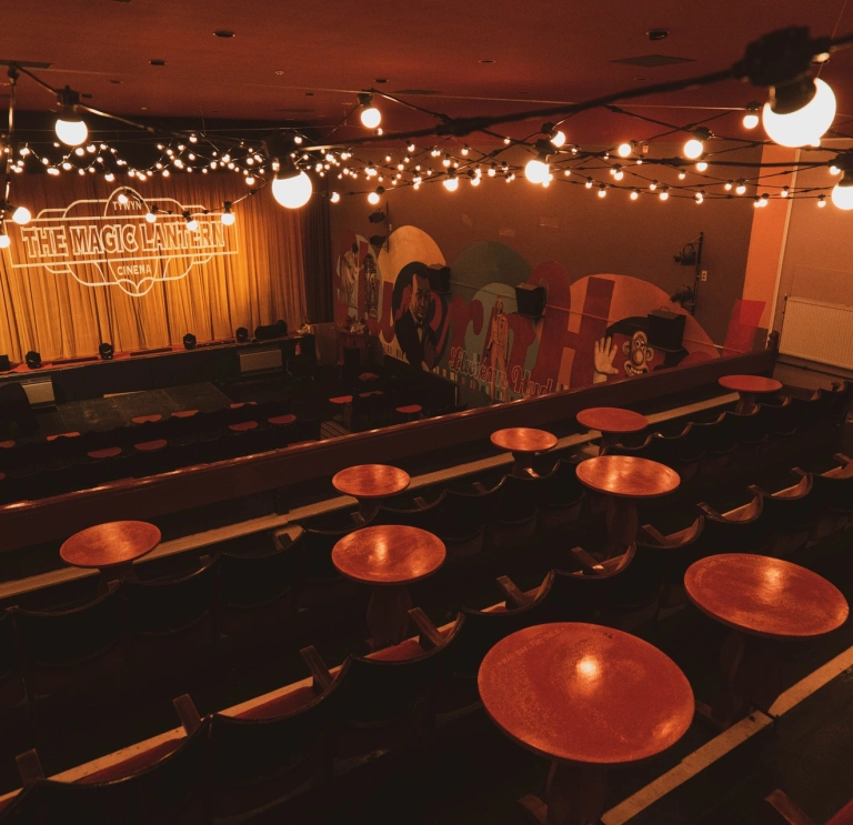 Inside of a theatre with stage and chairs.