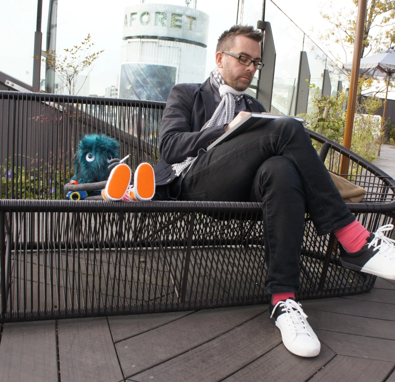 A man sitting on a bench and drawing.