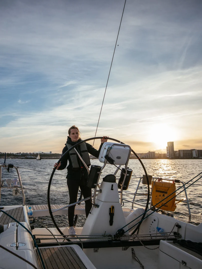 Hannah Mills at the wheel of the yacht, sailing in Cardiff Bay
