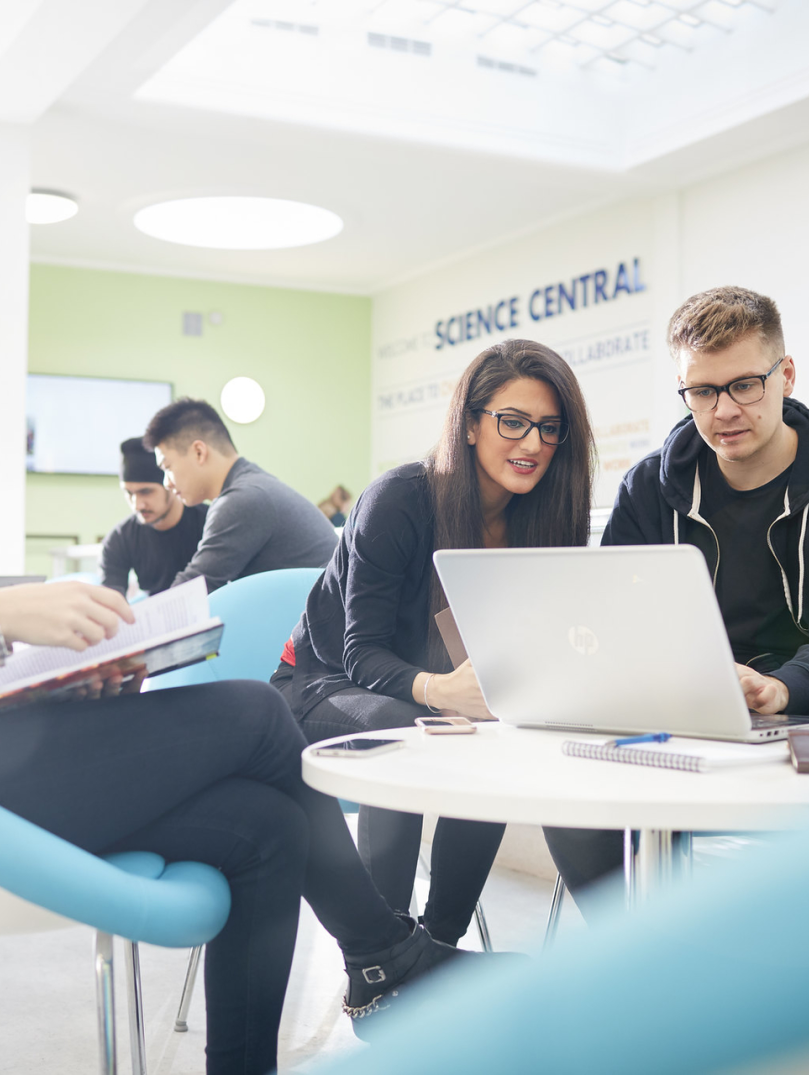 Students looking at laptop and notes
