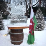 Photograph of an ice sculpture in the shape of the Welsh dragon, next to a Welsh flag