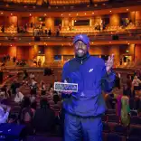 A man standing on stage holding an award.