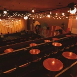 Inside of a theatre with stage and chairs.