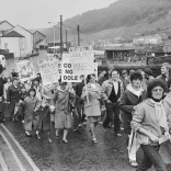 People walking down the street protesting.