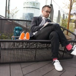 A man sitting on a bench and drawing.